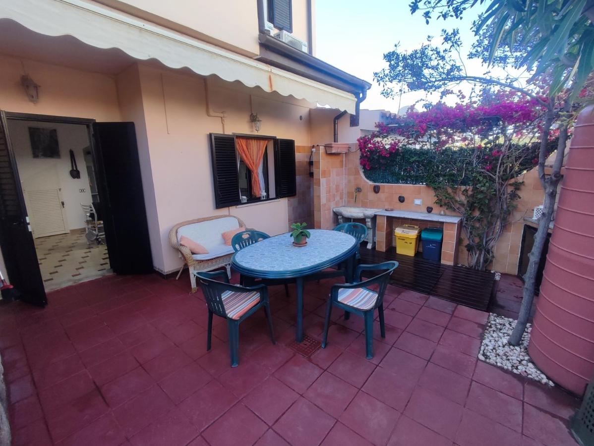 Patio fiorito con tavolo all'aperto, sedie e bouganville